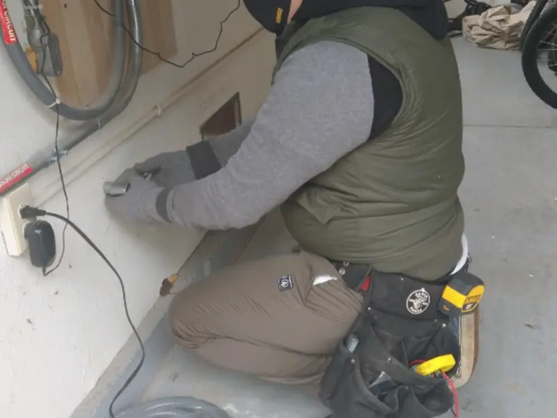 Electrician performing outlet wiring in a Lancaster garage